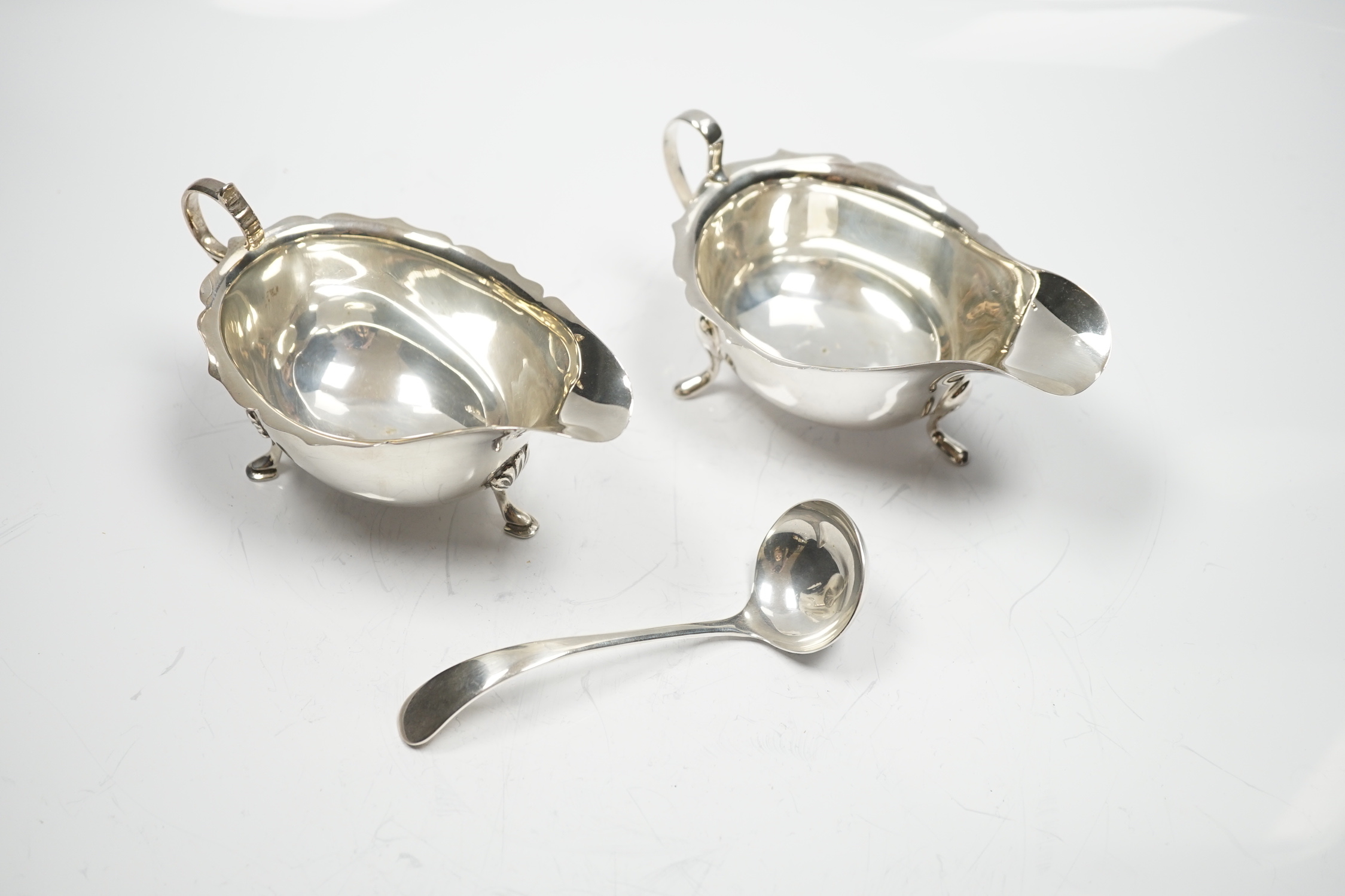 Two mid 20th century silver sauce boats and a similar silver sauce ladle, 8.1oz.